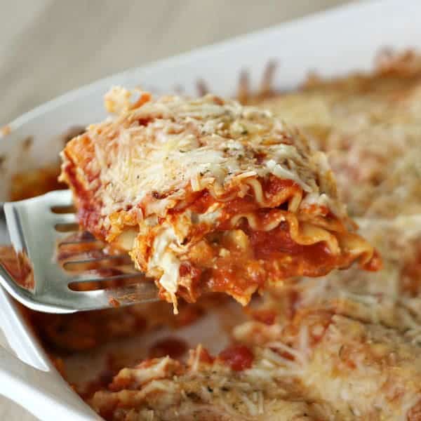 Piece of Creamy Chicken Lasagna  being removed from baking pan