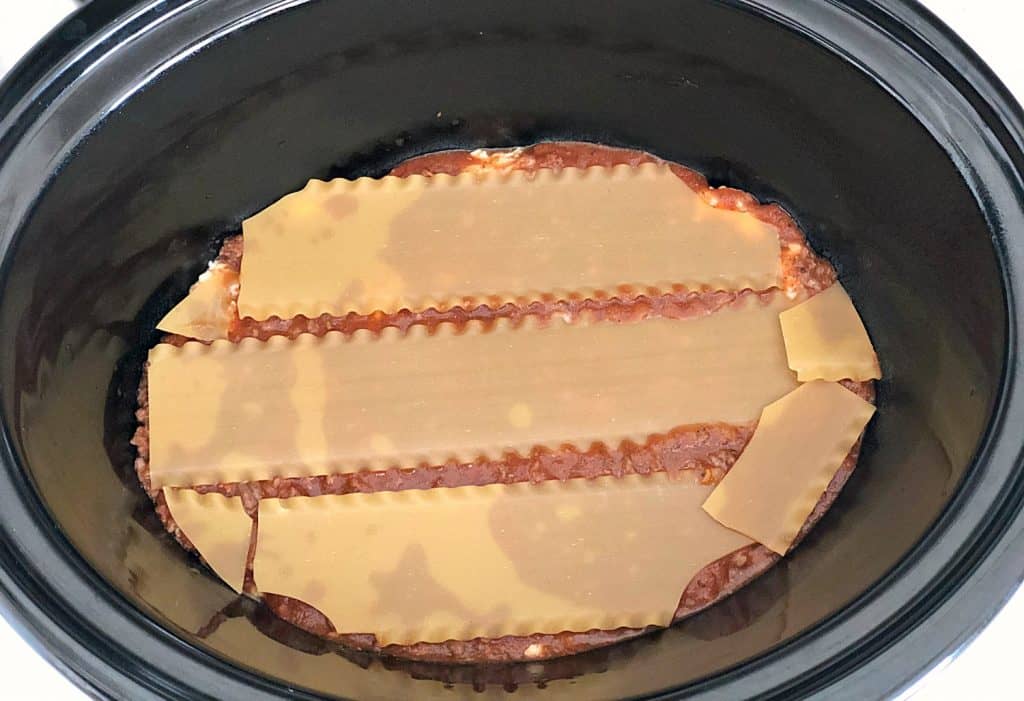 Sauce and lasagna noodles in the bottom of the slow cooker.