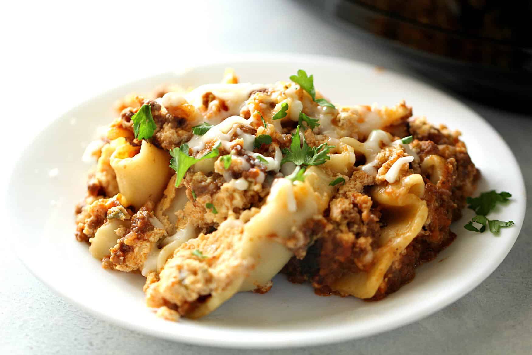 Lasagna dished on a plate topped with parsley