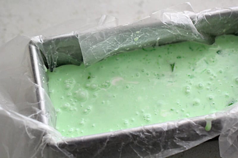 Frozen Creamy Lime Jello in a pan with saran wrap ready to go in the freezer