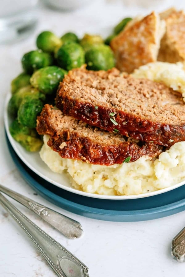 meatloaf slices with brussel sprouts on mashed potatoes