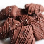 Homemade chocolate caramels with sea salt stacked in a pile.