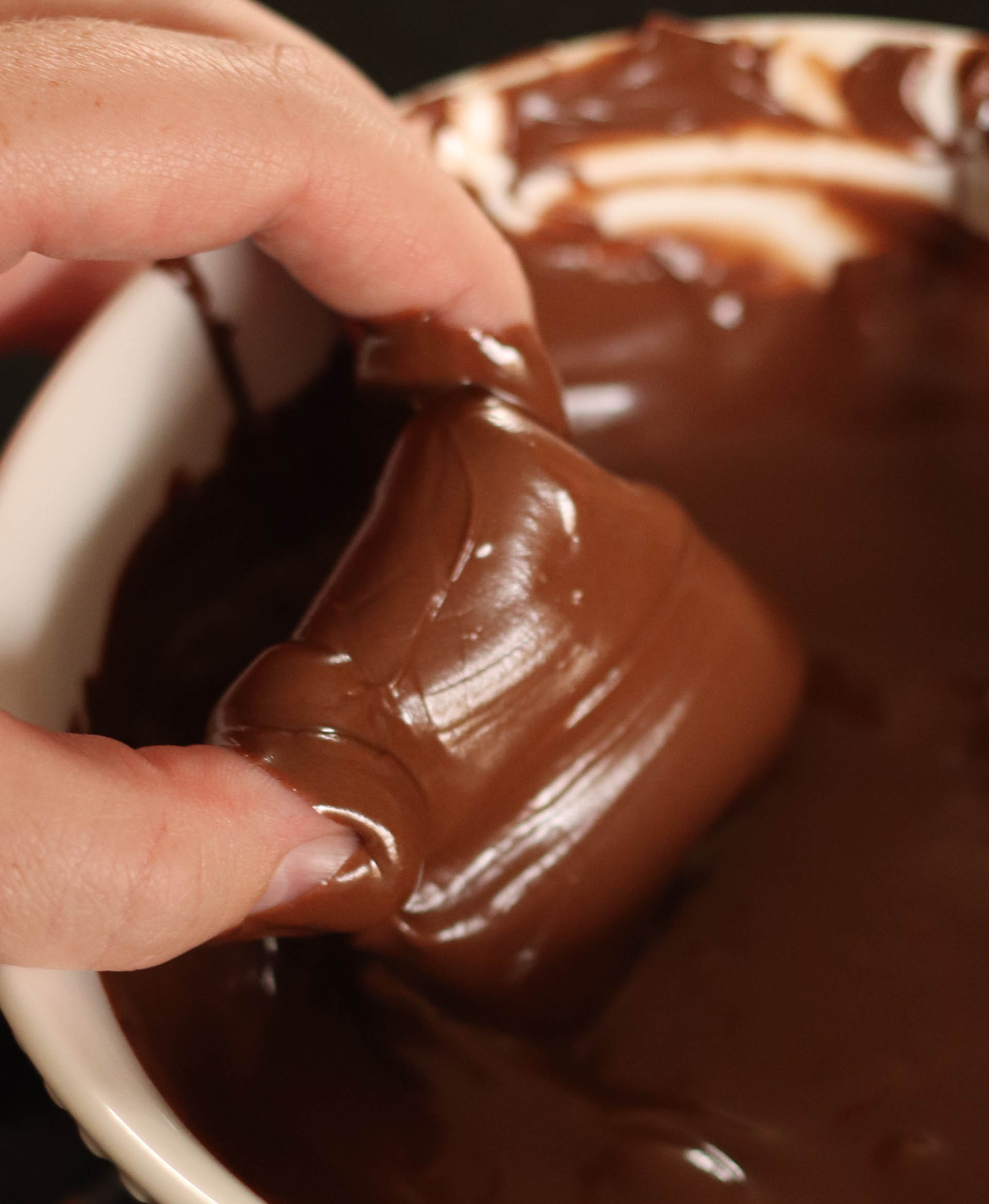 dipping caramels in melted chocolate 