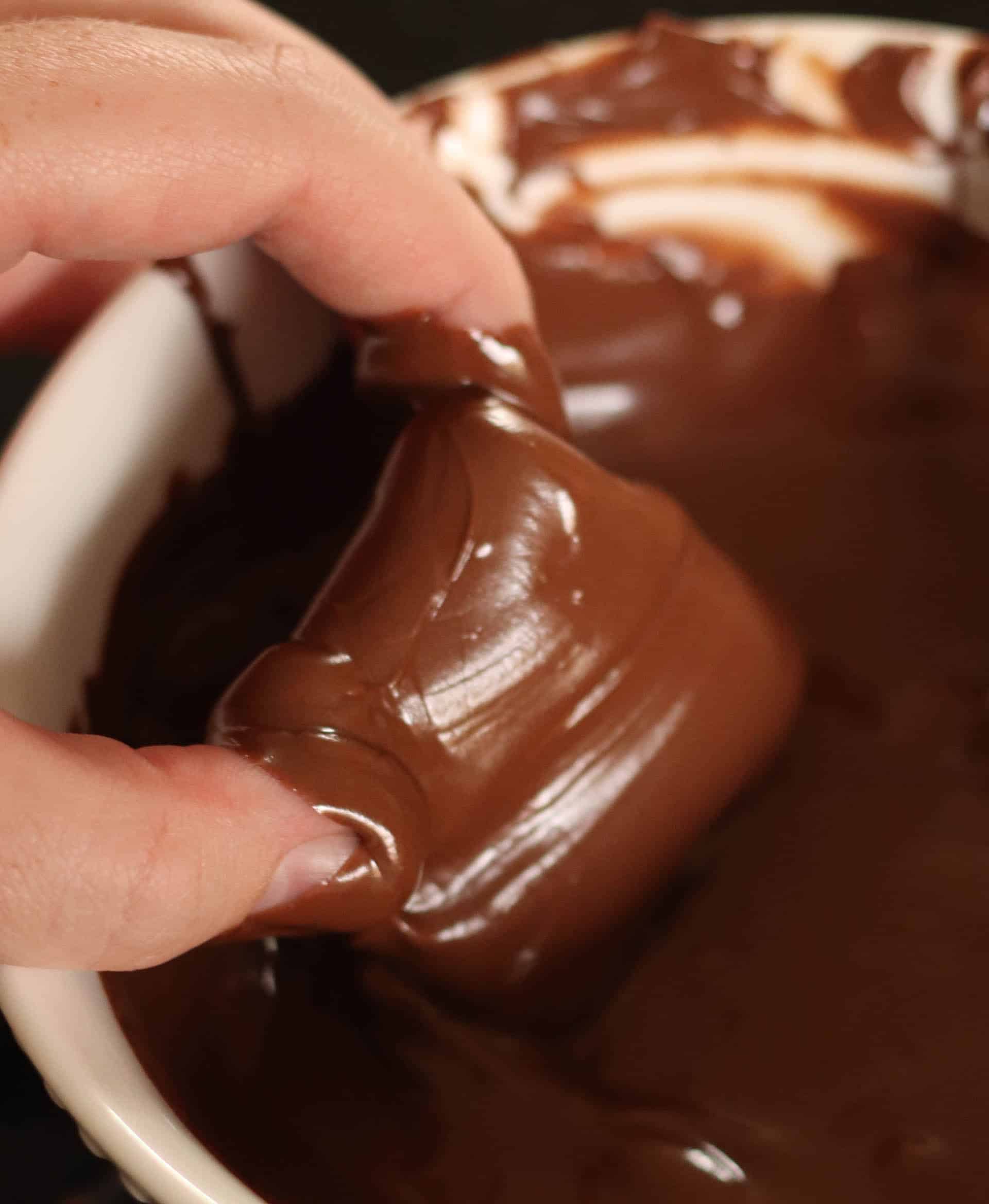 dipping caramels in melted chocolate