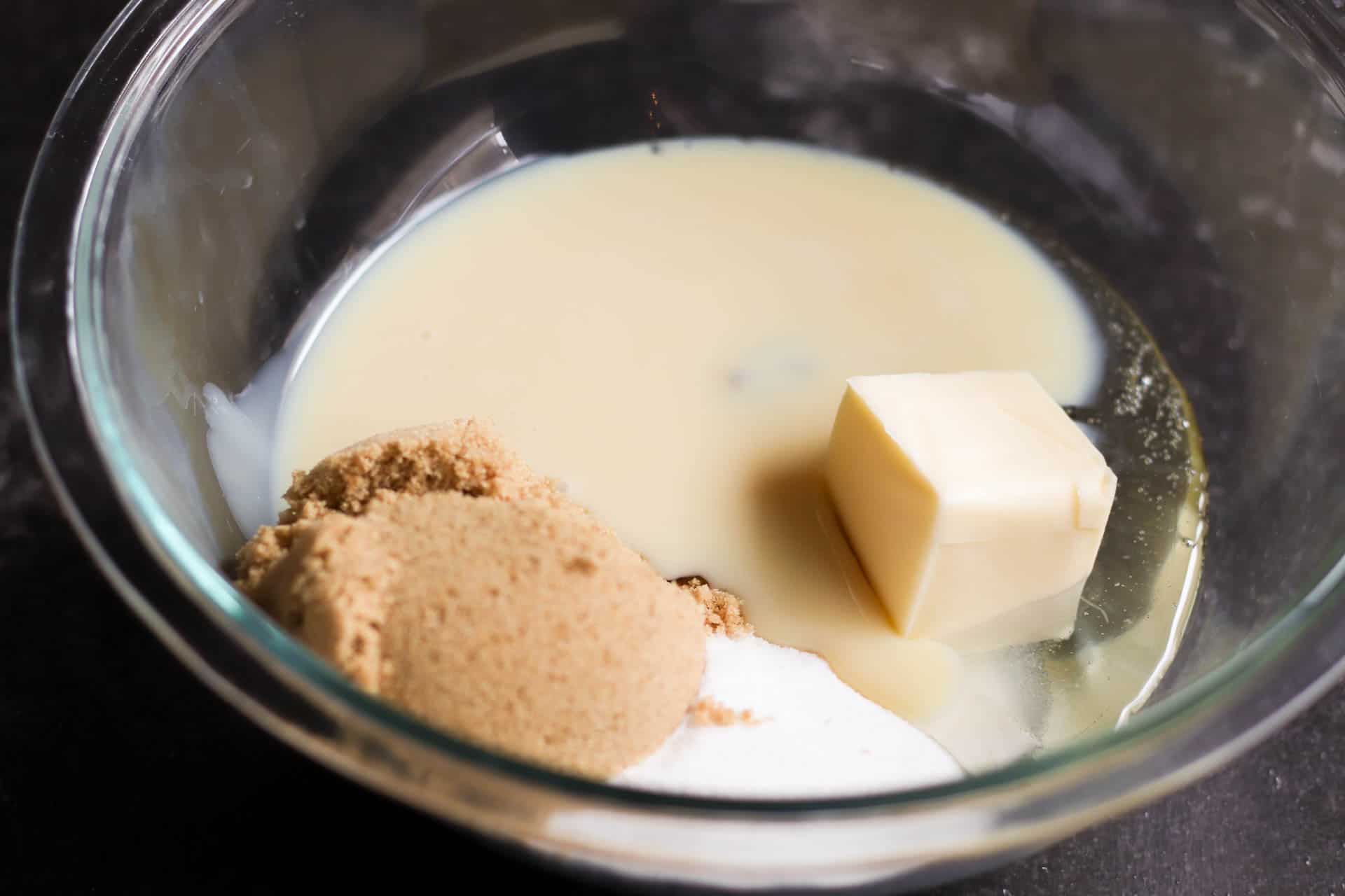 Ingredients for homemade caramels in a glass mixing bowl.