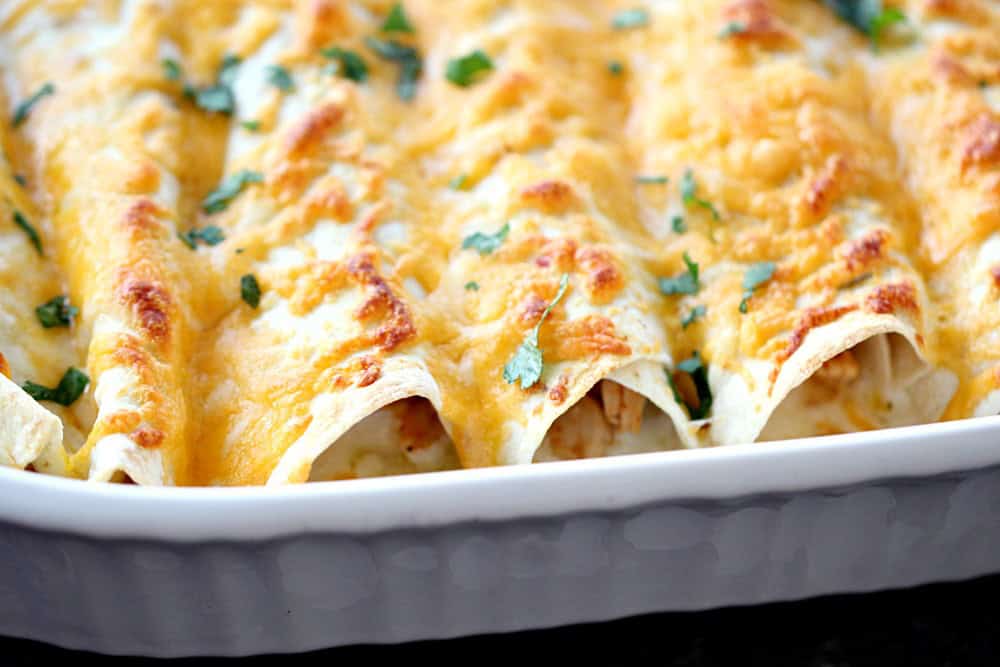 Honey Lime Chicken Enchiladas in white casserole dish