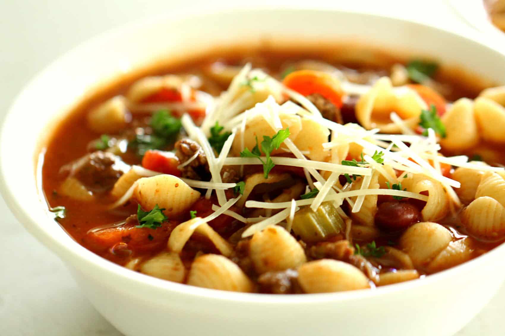 A bowl of Minestrone Soup with Italian Sausage topped with parmesan cheese