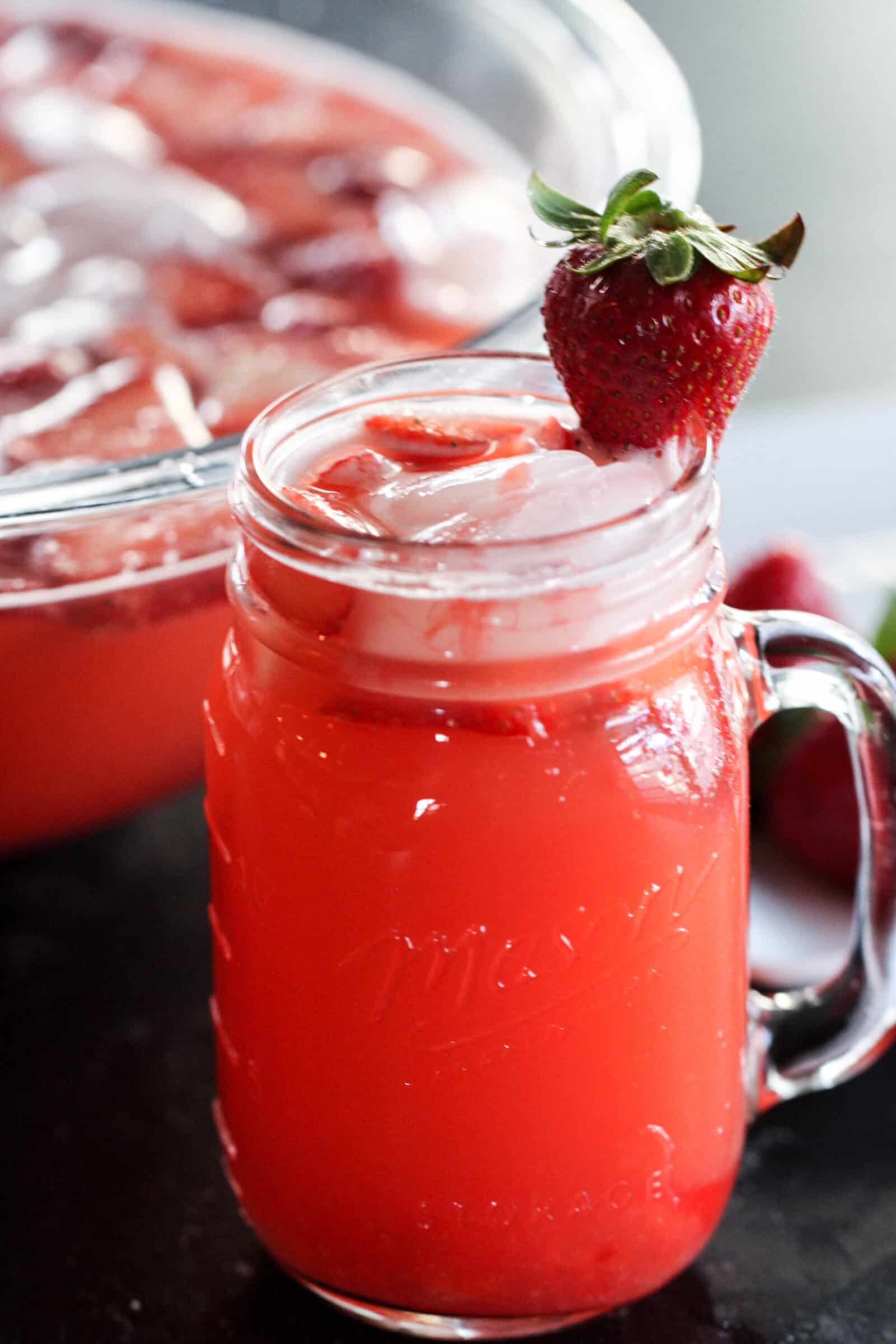 Strawberry Slush Drink in a glass mason jar topped with a fresh strawberry