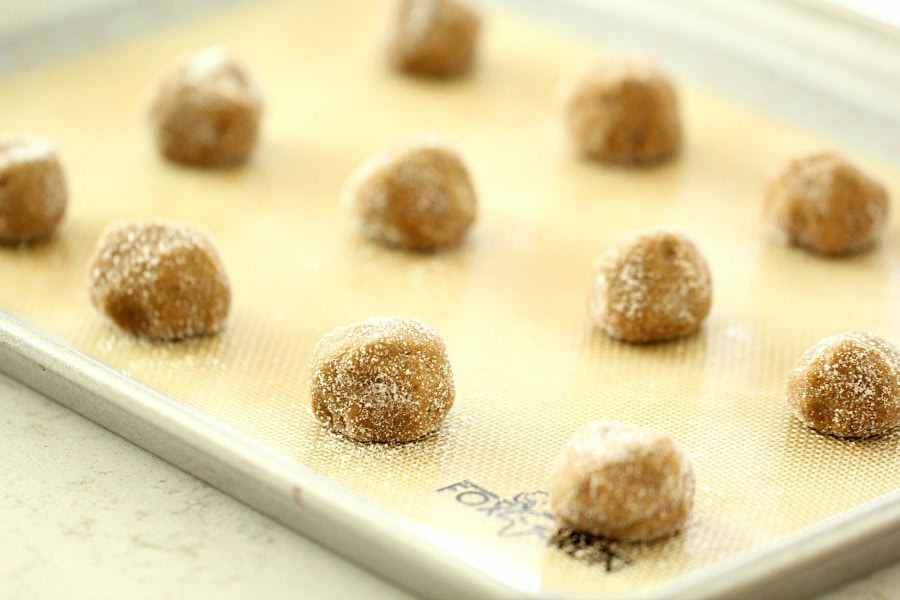 Cookie dough balls of ginger cookies on a baking sheet.