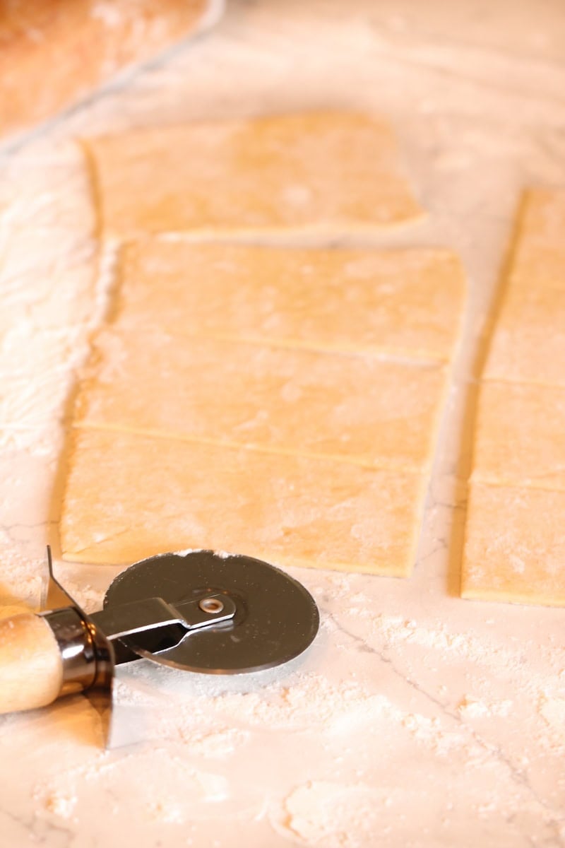 Crescent rolls rolled out on the counter and cut into 16 squares