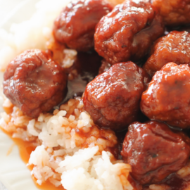 meatballs in sweet sauce over rice on a white plate