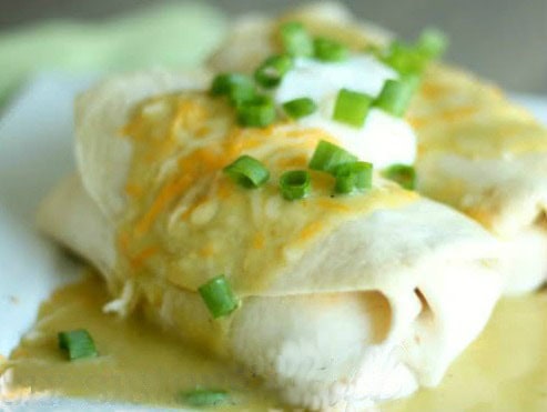 chicken chimichanga with green sauce, onions and sour cream