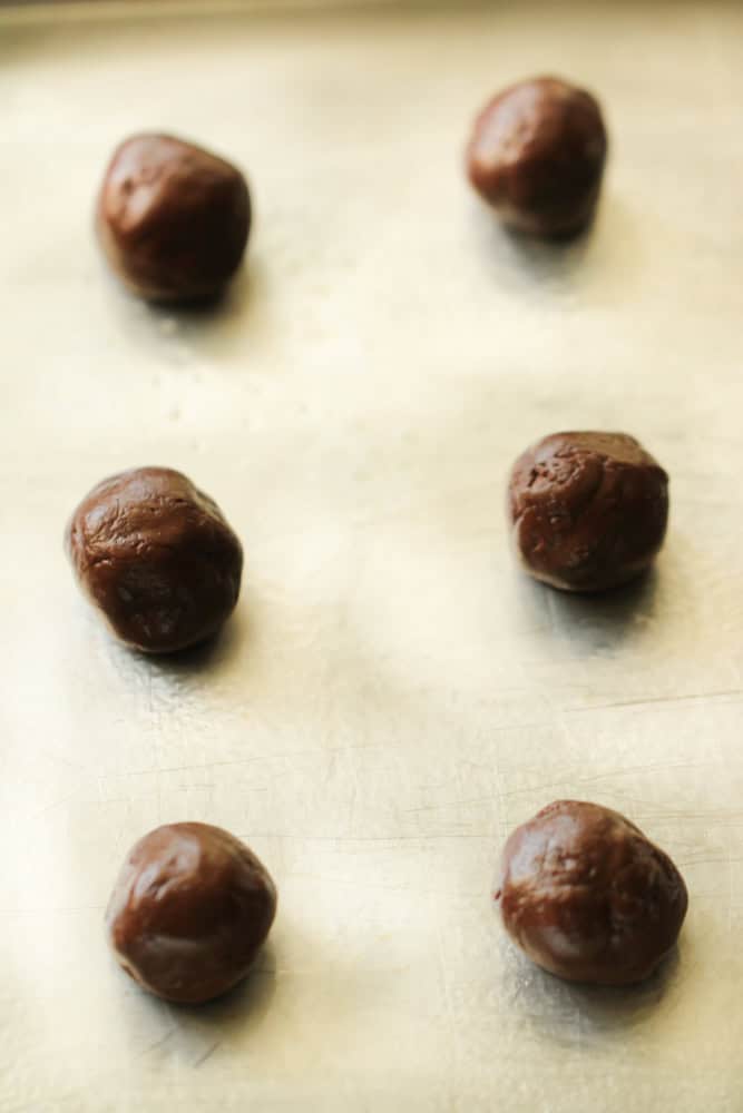 Rolo cookie dough balls on a baking sheet before they go in the oven.