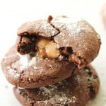 3 Rolo Cookies stacked on top of each other. The top cookie is broken in half to show the caramel center.