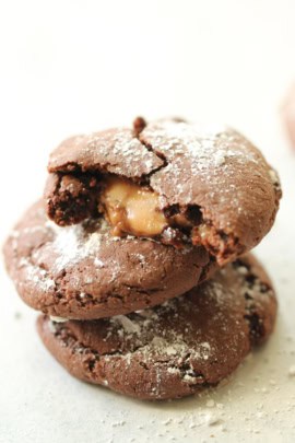 3 Rolo Cookies stacked on top of each other. The top cookie is broken in half to show the caramel center.