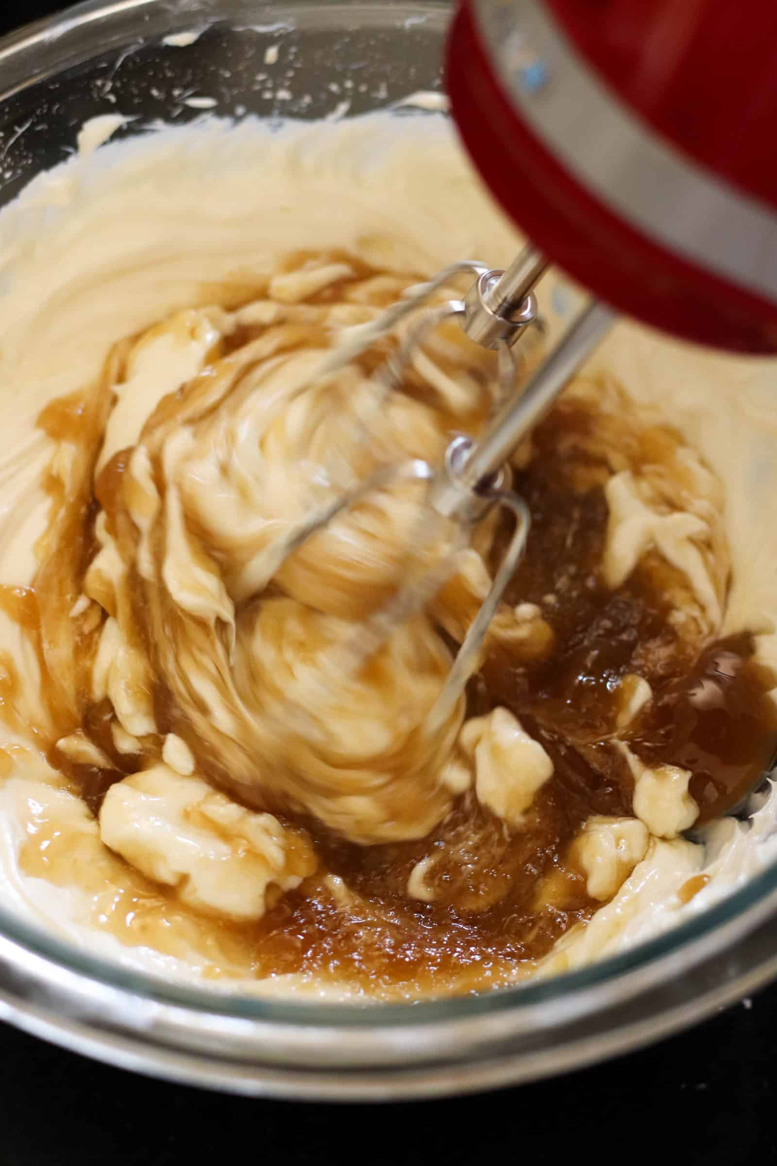 Pouring butter mixture into cream cheese mixture and mixing together