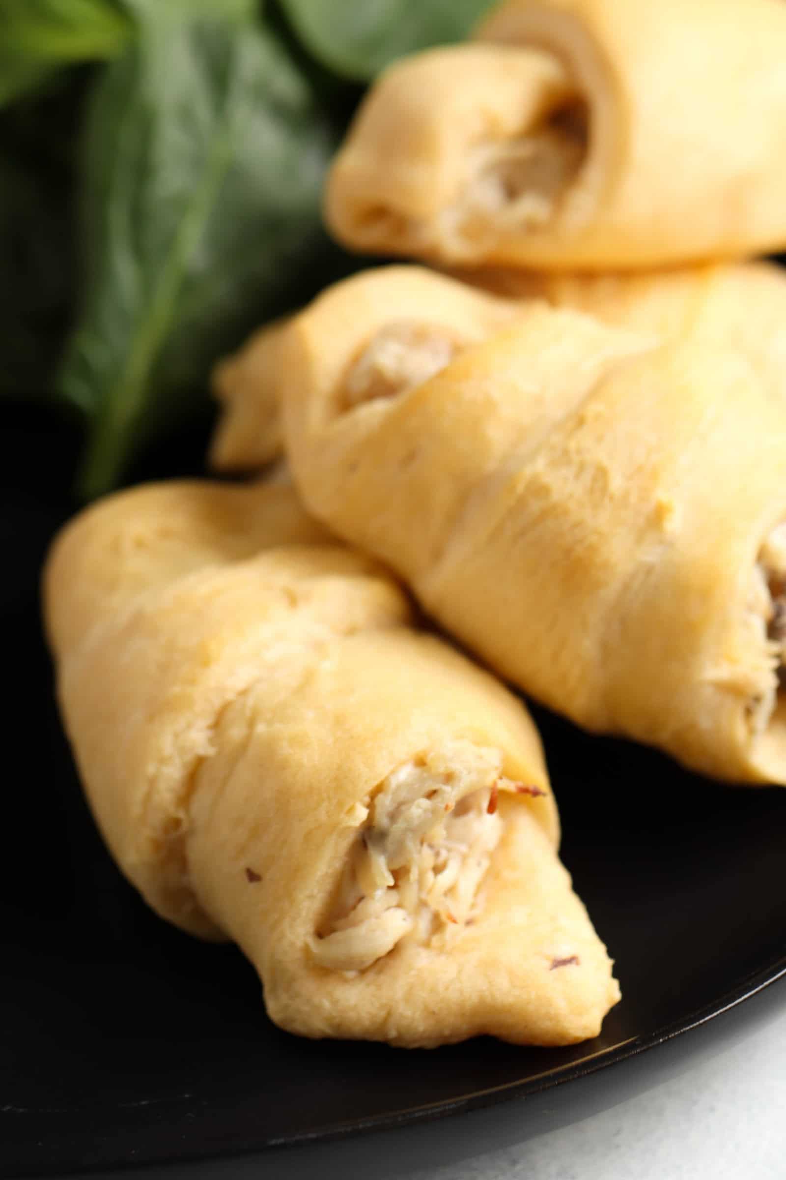 Mom’s Chicken and Cream Cheese Roll-Ups on a black plate with a salad