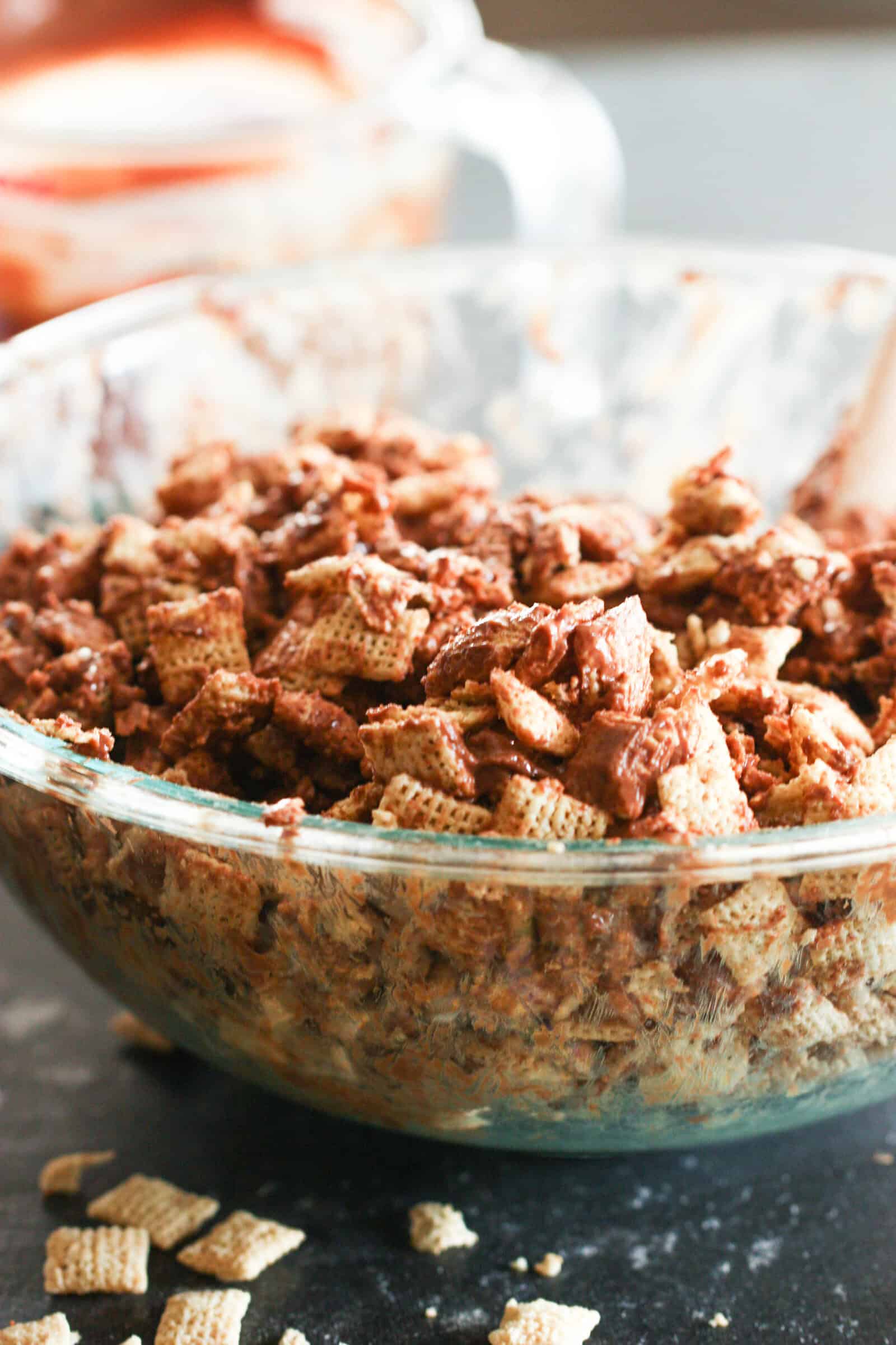 Mixing chocolate sauce into a bowl of chex cereal