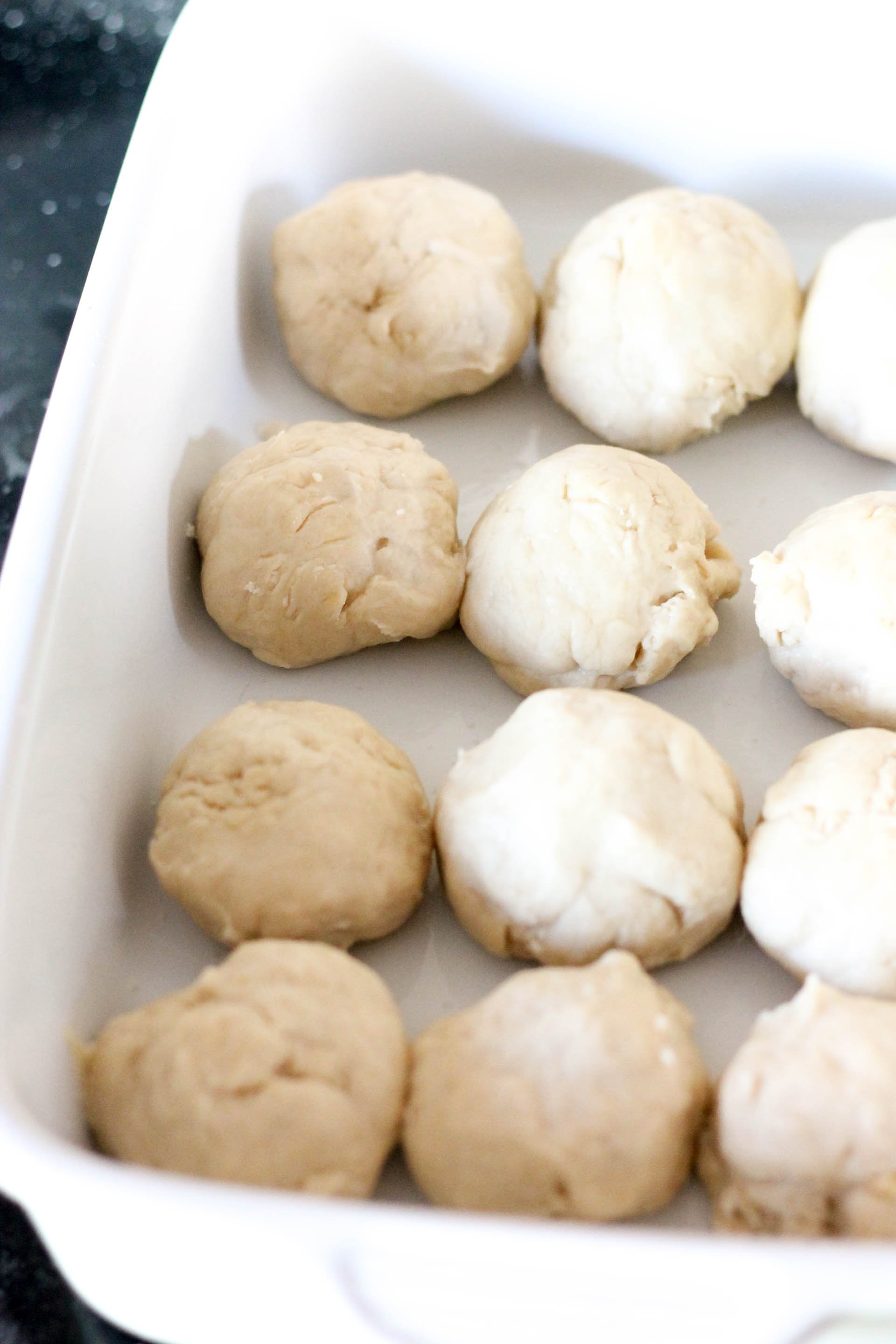 bread dough shaped into balls in bottom of 9x13 baking pan