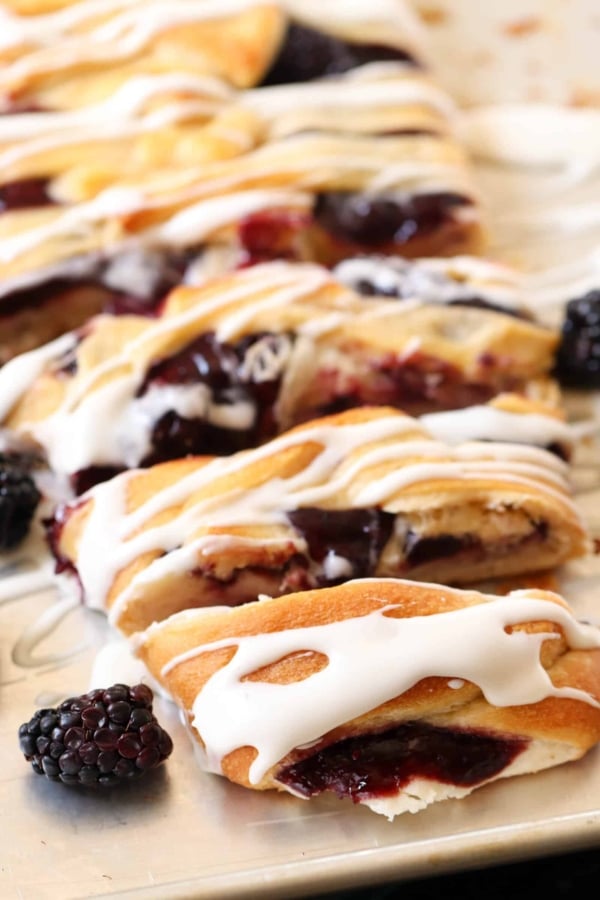blackberry danish with icing on a baking tray
