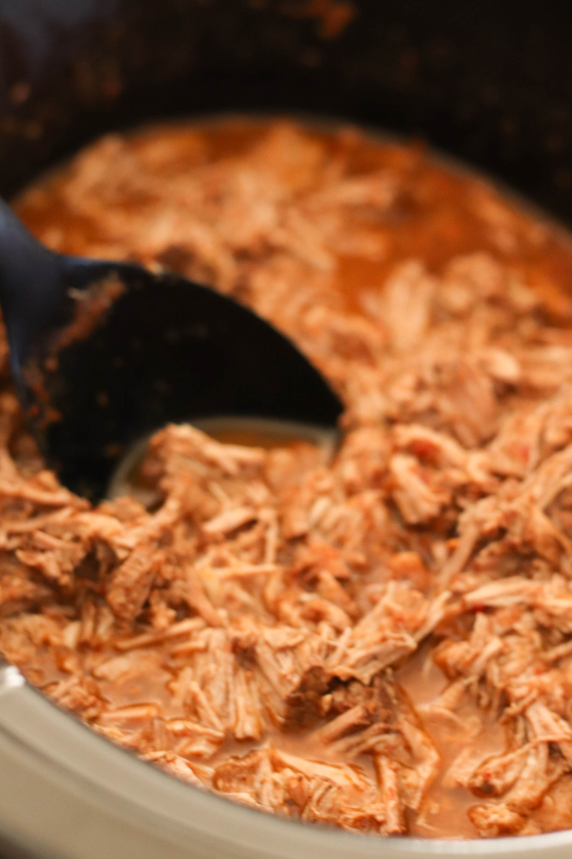 Slow Cooker Chipotle Barbacoa in the slow cooker with a serving spoon