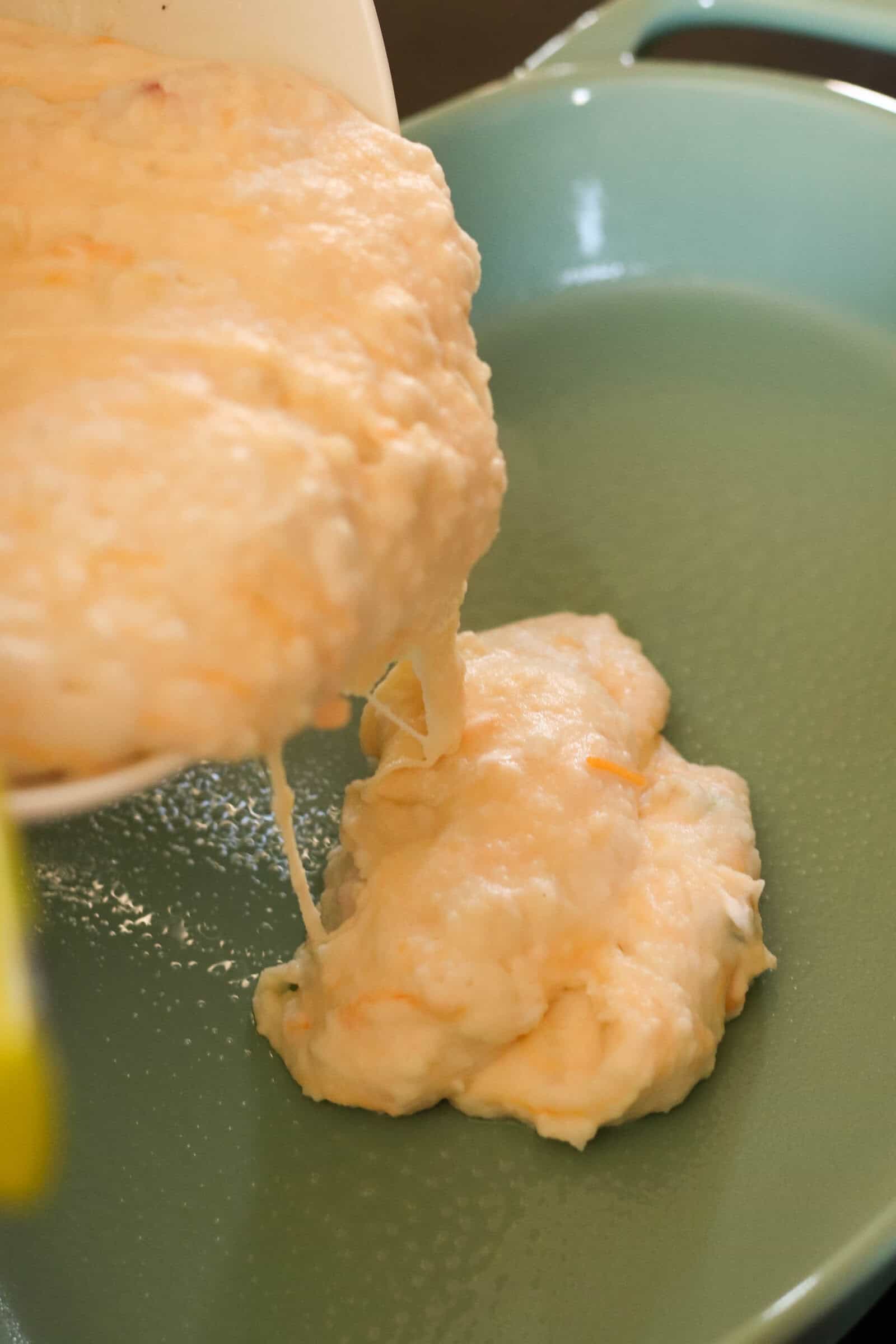 Cheesy Potato Mixture being poured into a greased 9x13-inch baking pan