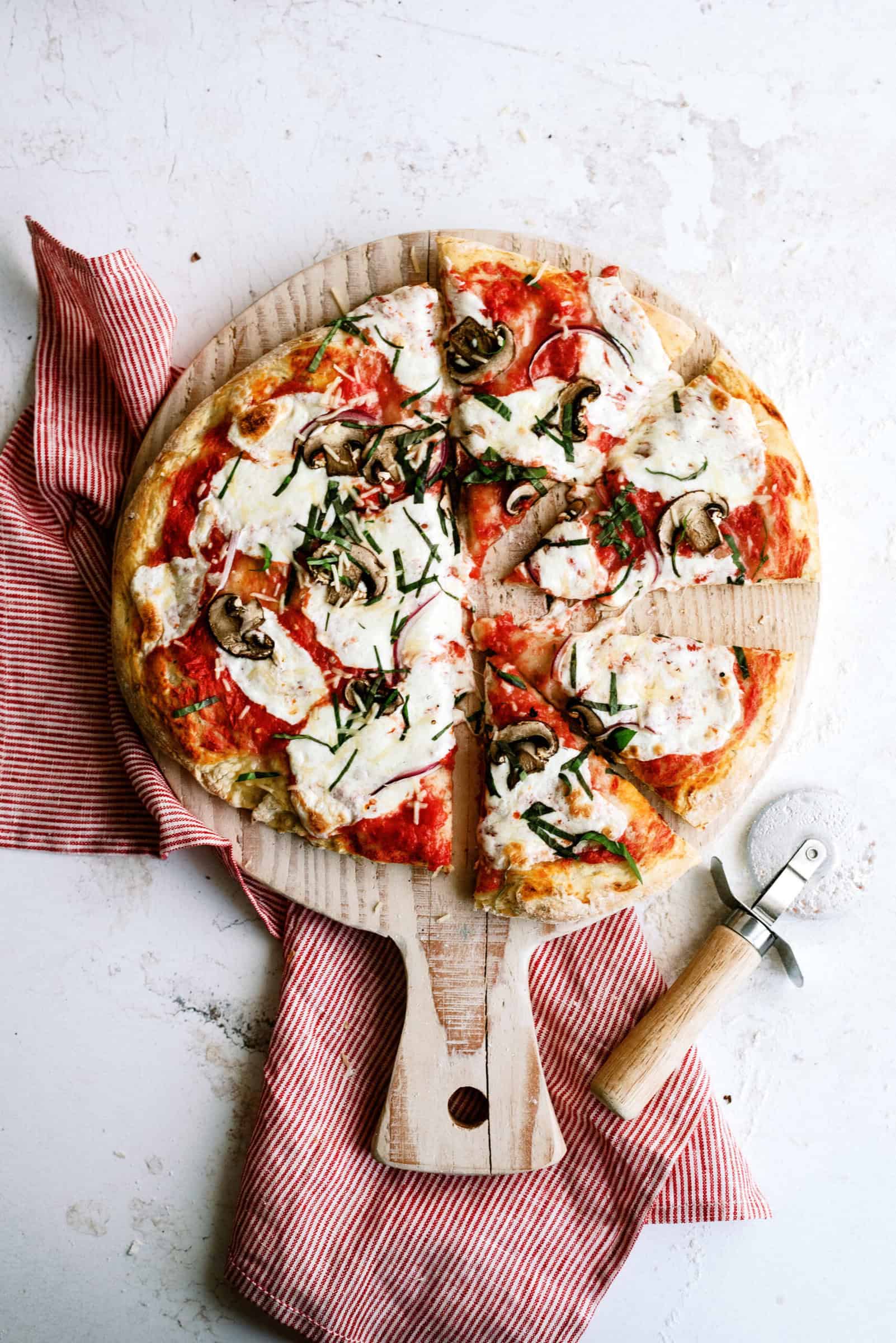 Homemade pizza with toppings on wooden pizza board