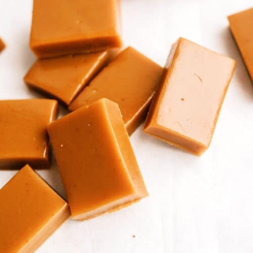 Homemade caramel candies arranged on a white surface.
