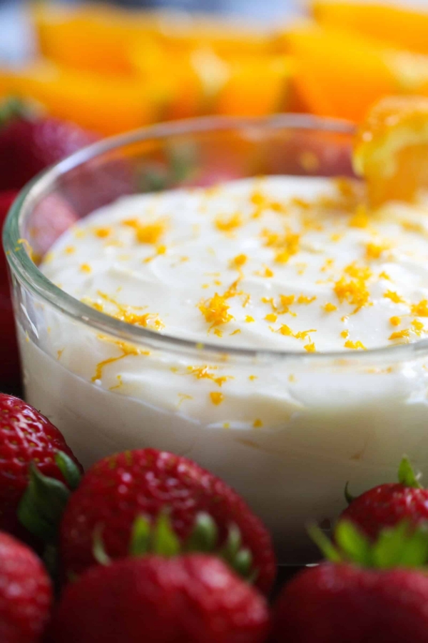 A bowl of Orange Creamsicle Fruit Dip surrounded by fresh fruit.