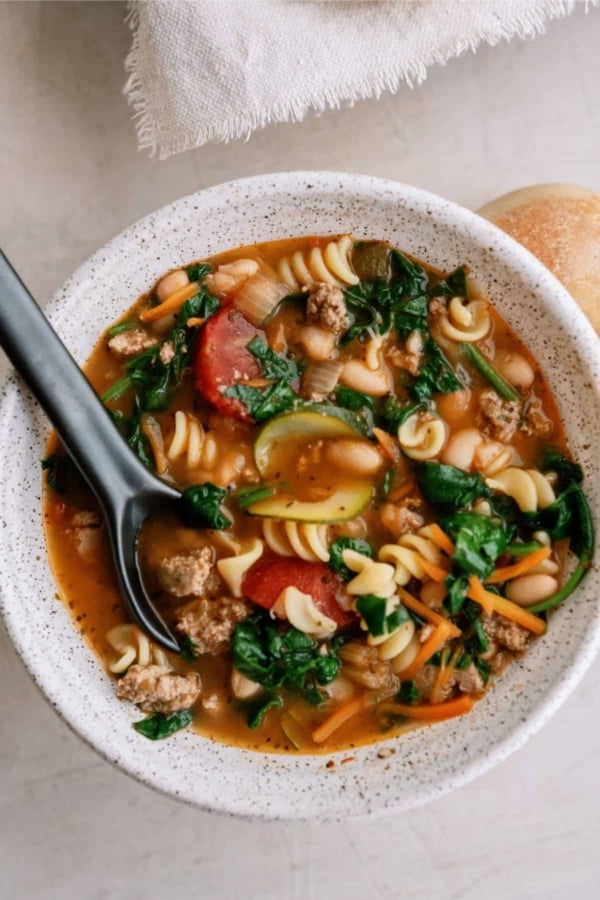 Top view of a bowl of Quick Italian Ground Turkey Soup with a spoon.