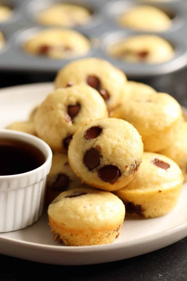 Mini Maple Pancake Muffins on a plate with a small cup of syrup.