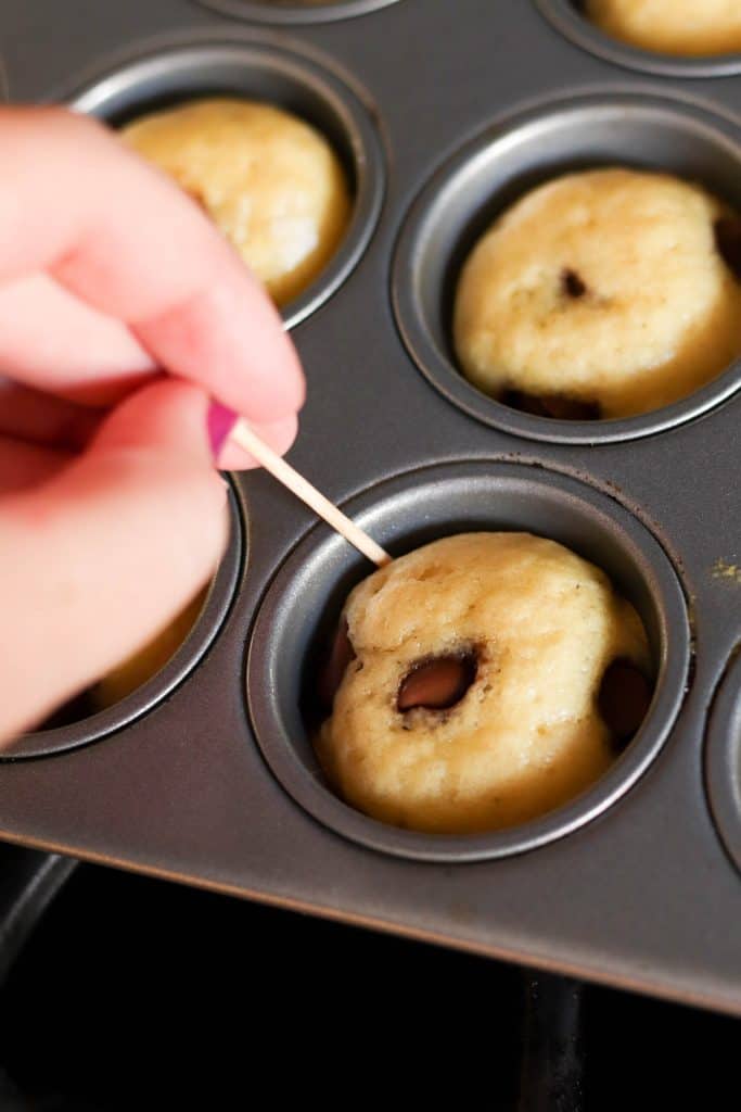 Using a toothpick to release Mini Maple Pancake Muffins from muffin tin.