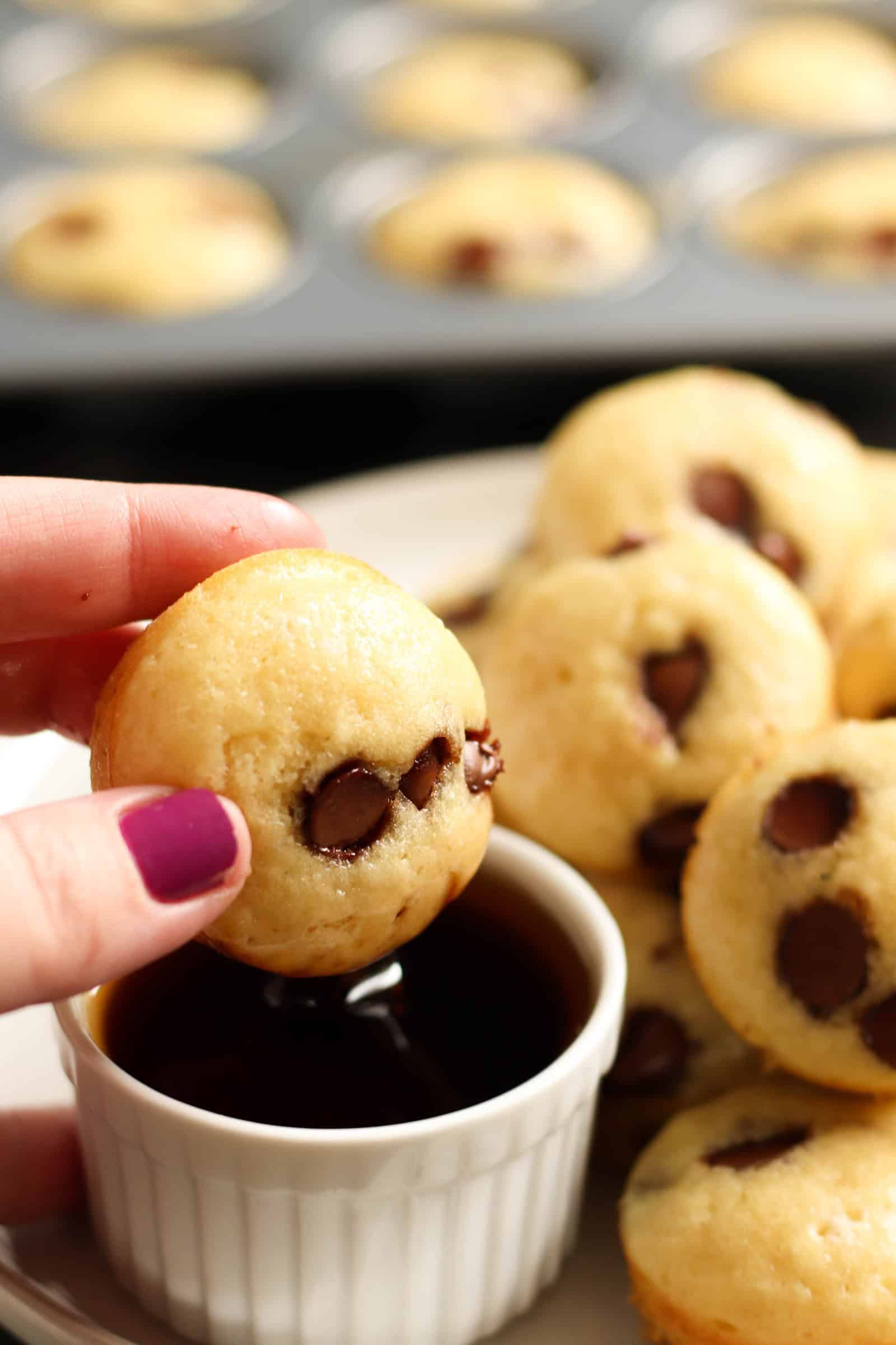 Mini Maple Pancake Muffins on a plate with one being dipped in a side of syrup