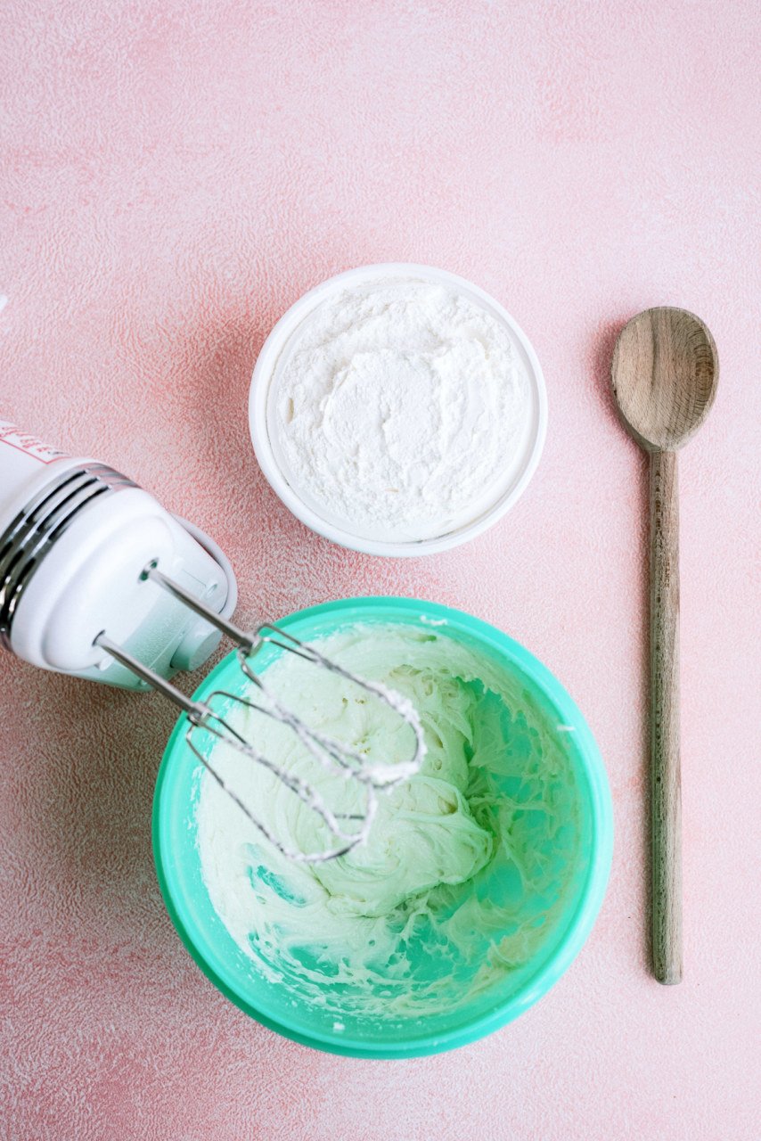 cream cheese mixture in a bowl next to a hand mixer