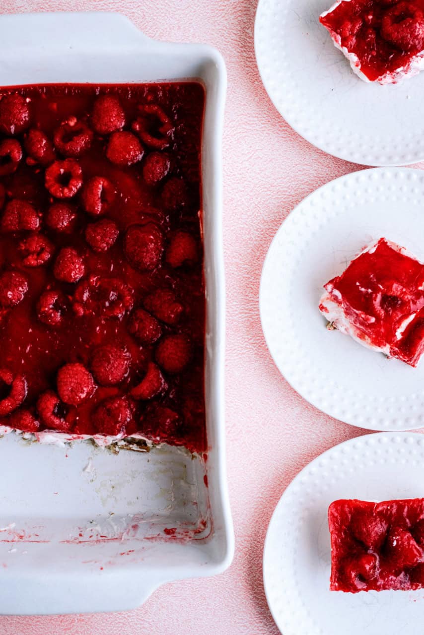 Raspberry Pretzel Jello Salad in a 9x13 inch pan and servings on plates