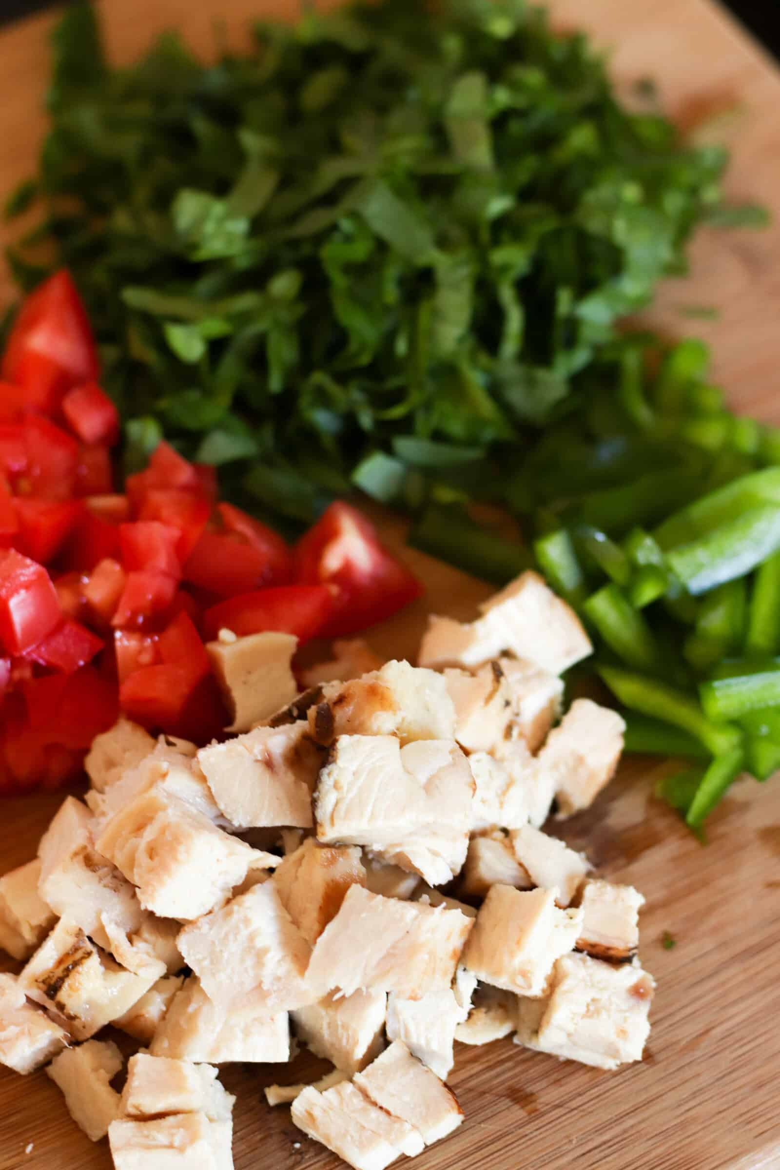 Chopped chicken and veggies on a cutting board