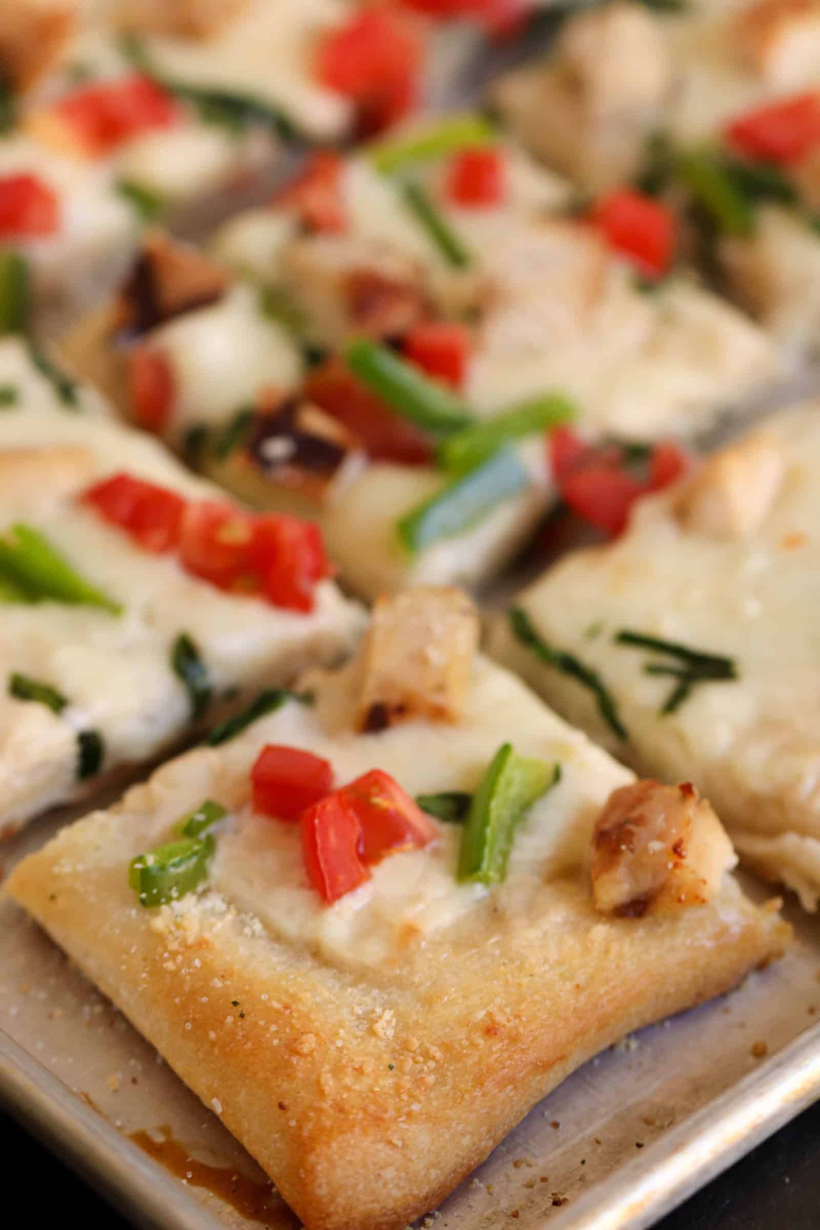 Alfredo Grilled Chicken Pizza cut into squares on a sheet pan