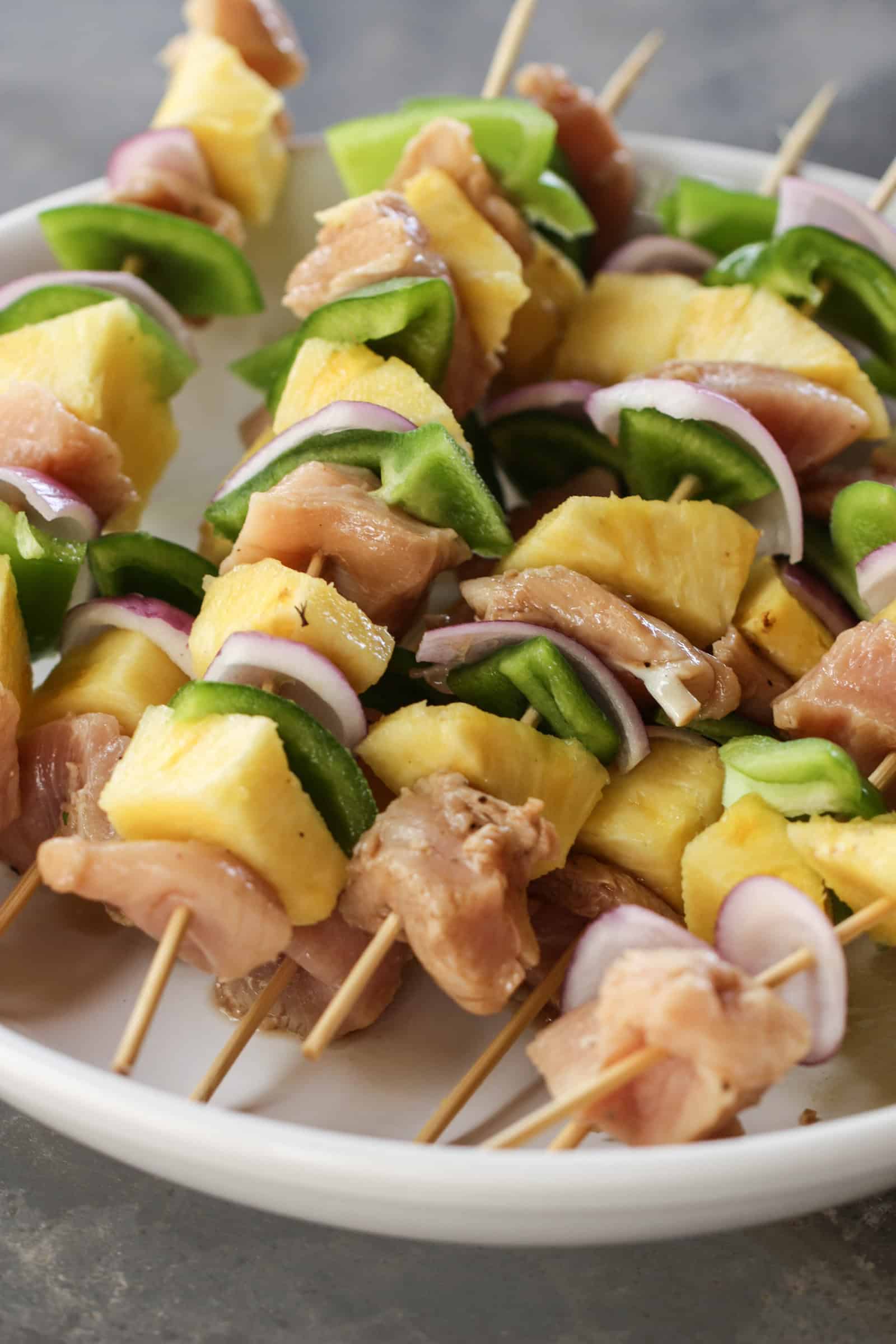 Raw Grilled Island Chicken Kabobs on a white plate