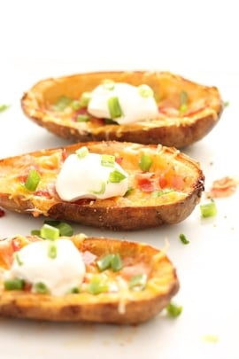 Loaded Baked Potato Skins plated and ready to eat with a dollop of sour cream on top