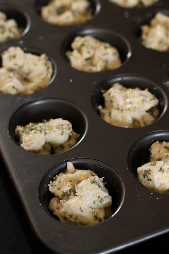 Mini Garlic Monkey Bread dough in a muffin cups.