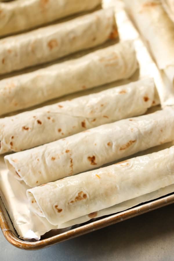 Unbaked Beef Taquitos on a baking sheet covered with foil