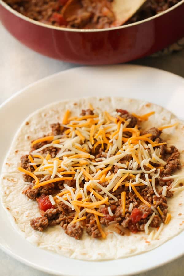 Tortilla filled with ingredients for Baked Beef Taquitos 
