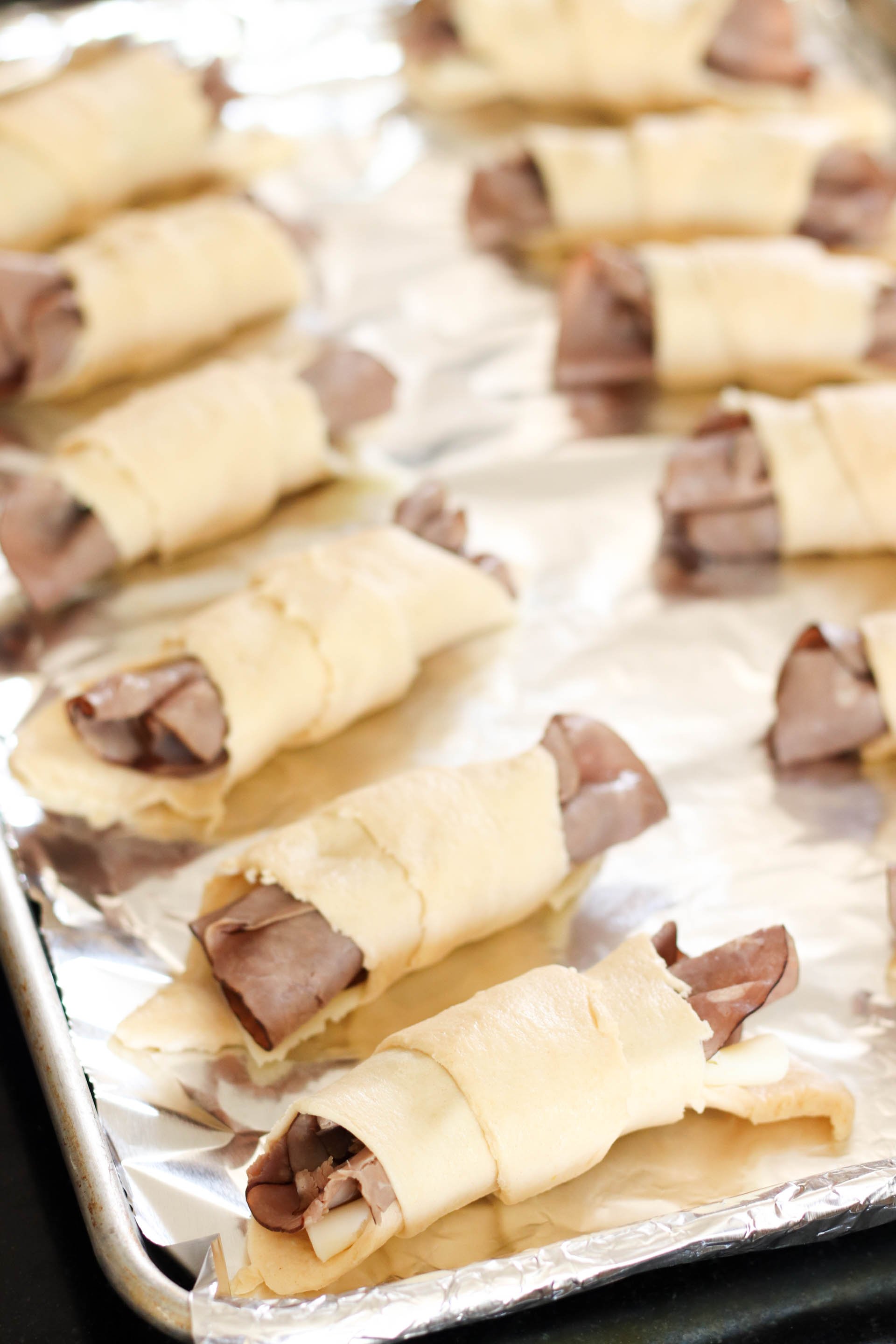 Rolled up crescents with meat and cheese inside, waiting to be cooked