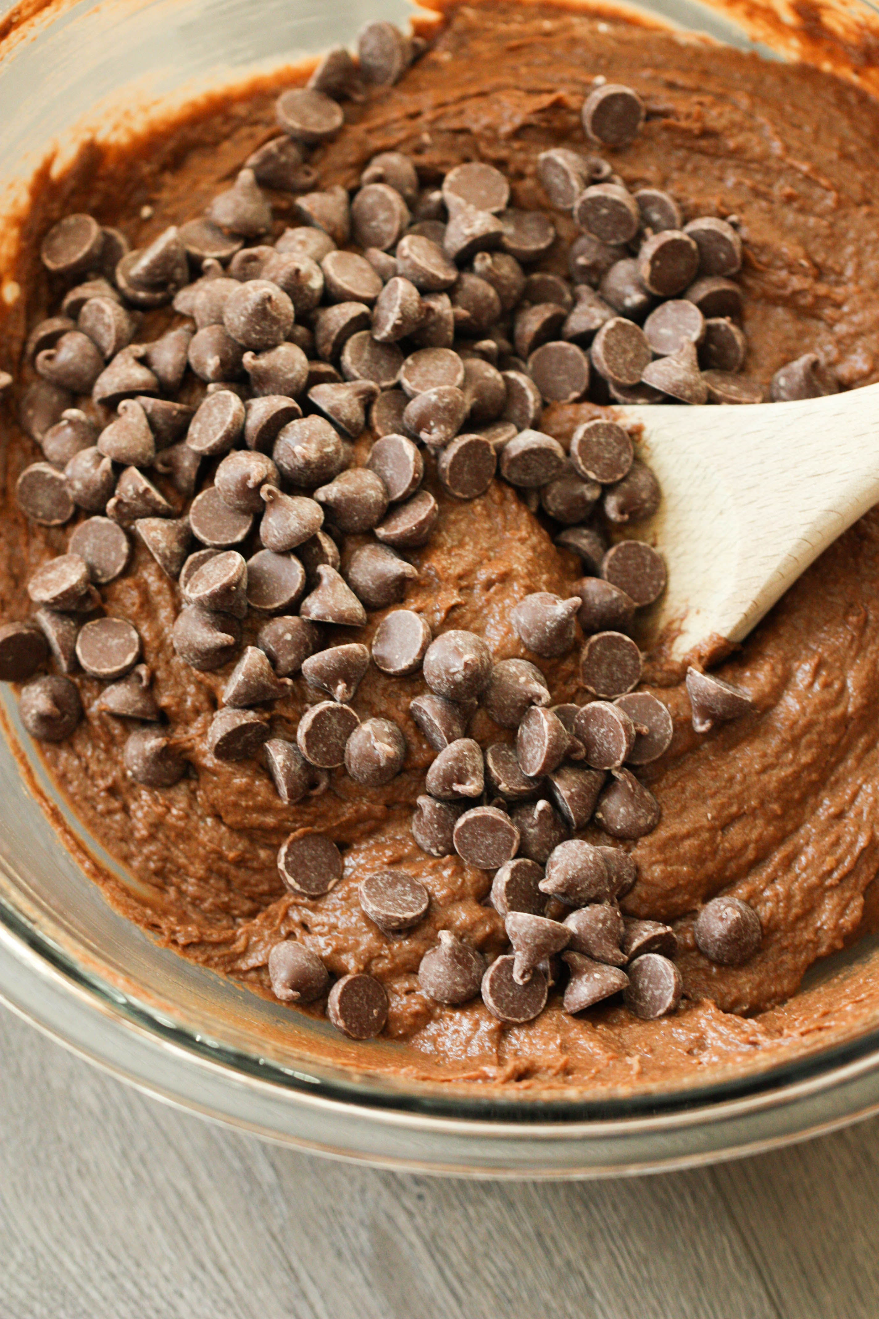 Chocolate Pumpkin Muffin batter in a glass bowl mixed with chocolate chips