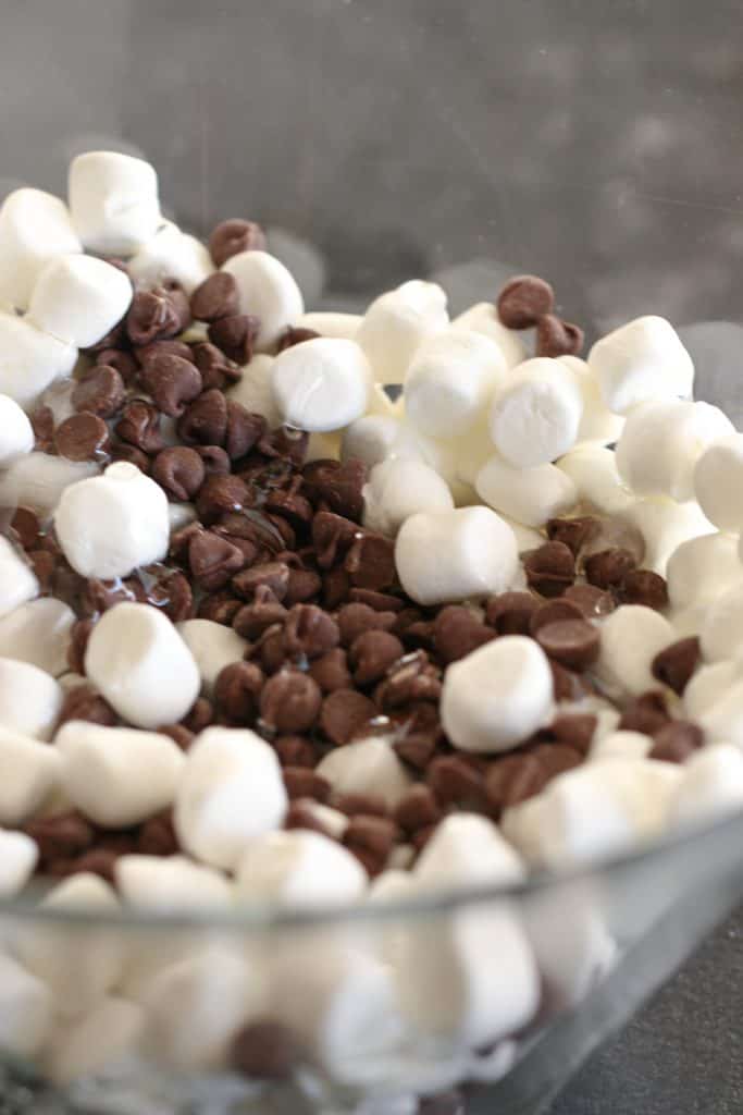 Chocolate chips and marshmallows in a glass bowl.