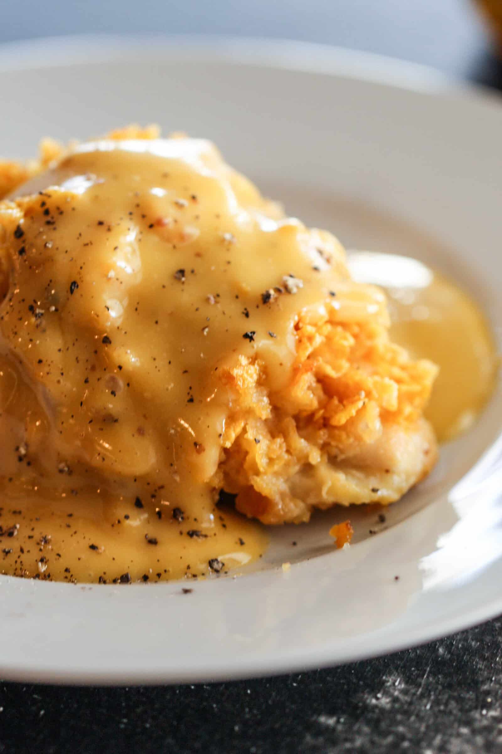 Crispy Honey Mustard Chicken on a white plate drizzled with honey mustard sauce