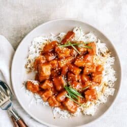 Slow cooker sweet and tangy pork served over white rice with herbs.