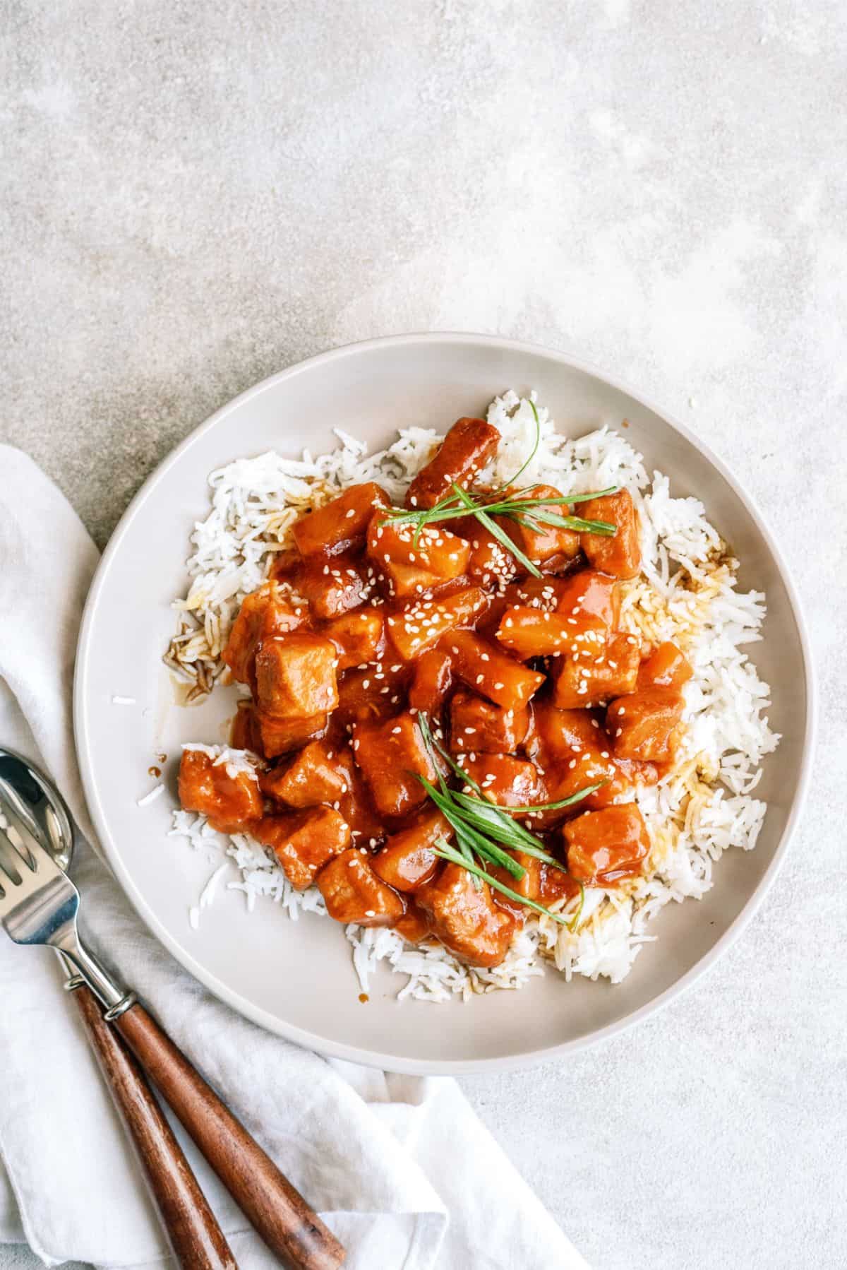 Slow Cooker Sweet and Tangy Pork served over rice on a plate