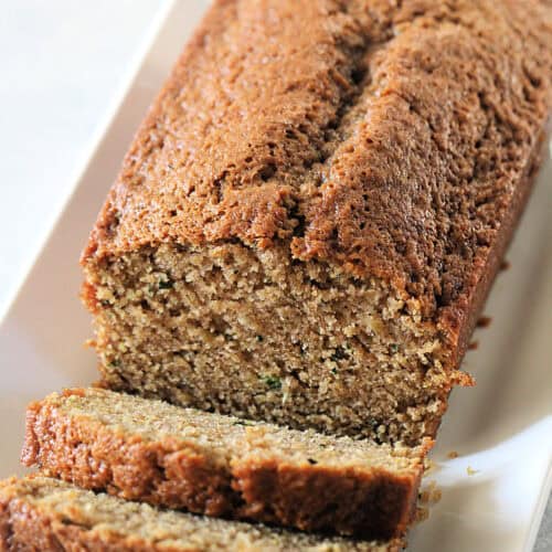 A loaf of Classic Zucchini Bread with the front of the loaf sliced.