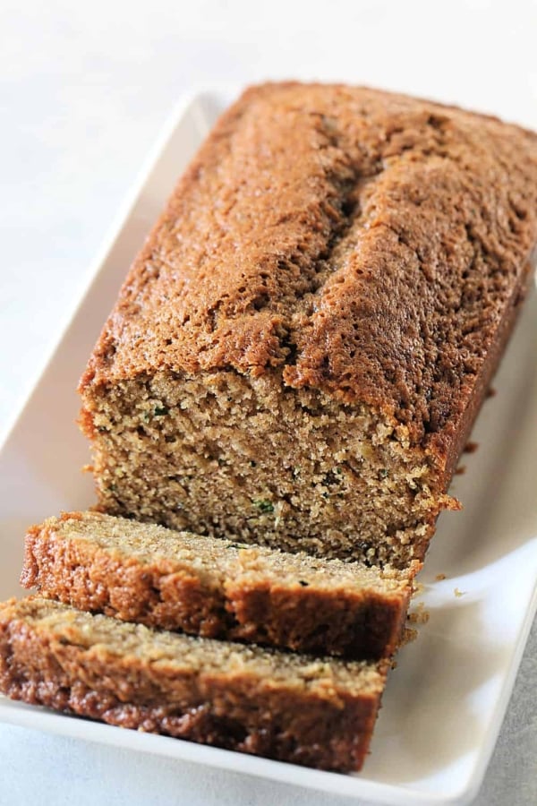 A loaf of Classic Zucchini Bread with the front of the loaf sliced.